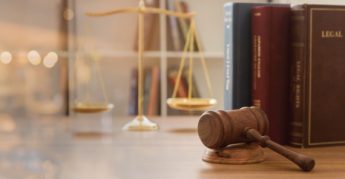 Mazo del juez con libros de la ley y balanzas de justicia.