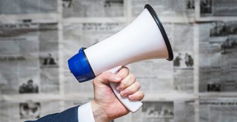  Mano de hombre sosteniendo un megáfono